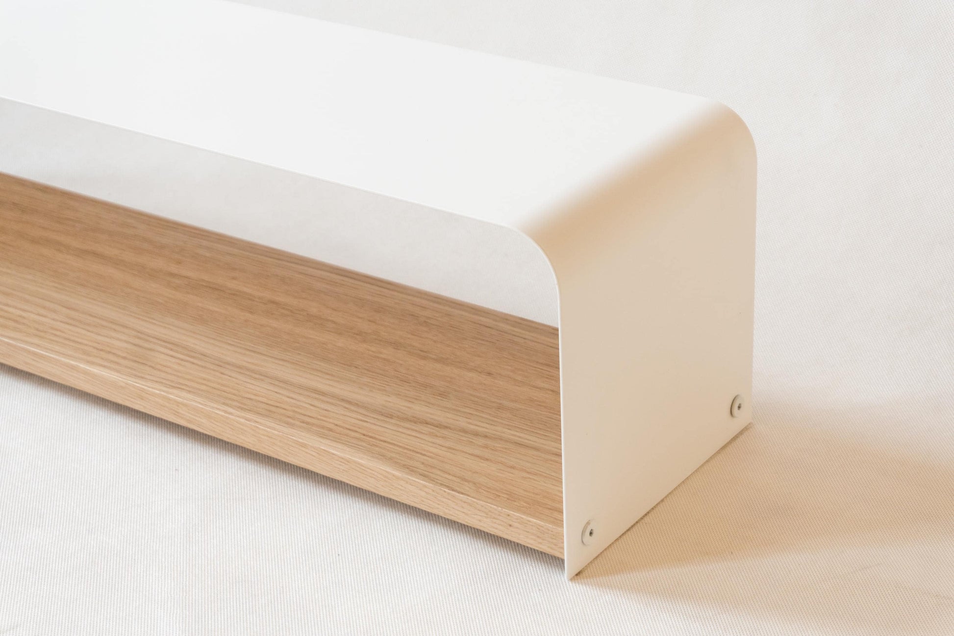 Minimalistyczny metalowy stojak na buty z białą metalową górą i drewnianą dolną półką.